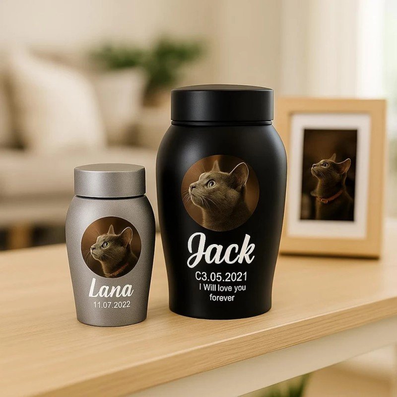 Lifestyle Shot Of Small Silver & Large Black Custom Stainless Steel Pet Cremation Urn, Engraved Cat Photo Name Date Ashes Storage Jar For Home Desktop Memorial Decor
